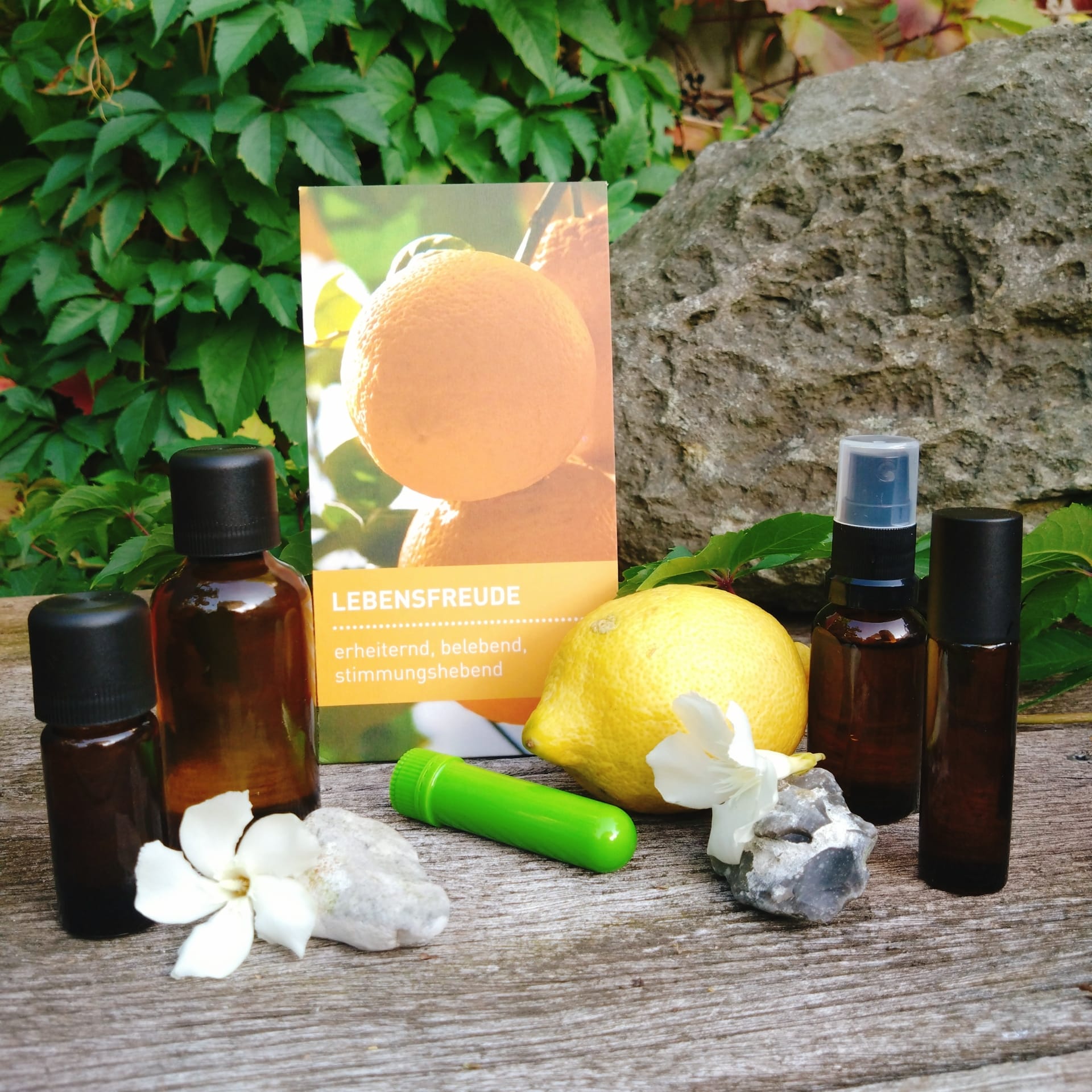 Aromaölflaschen mit Zirone und einem Bild zu Lebensfreude mit Abbildung von Orangen